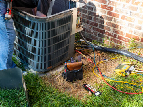 HVAC technician maintaining an air conditioner