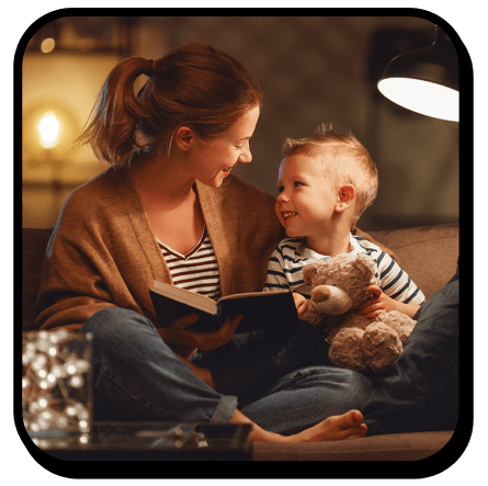 Mother and son cozy on the couch reading a book