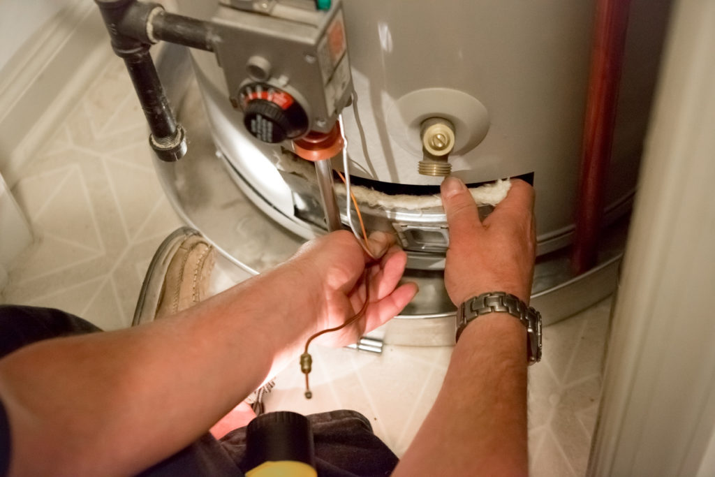 Plumber servicing a storage tank water heater